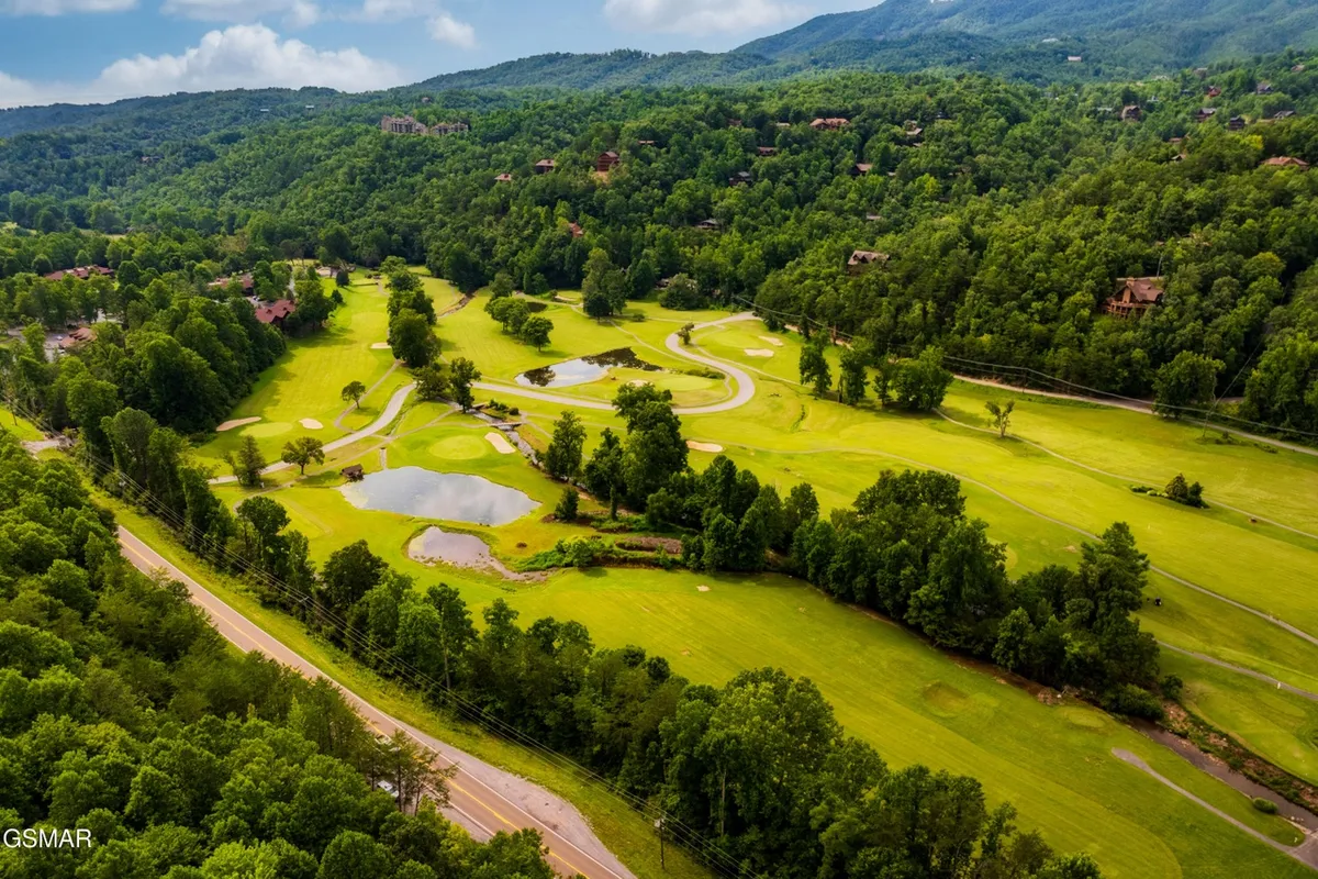A wide view of the Bent Creek Golf Course, featuring rolling green hills, scenic ponds, and lush natural surroundings perfect for a day of golfing or leisurely exploration. The tranquil setting is ideal for groups of friends seeking both activity and relaxation.