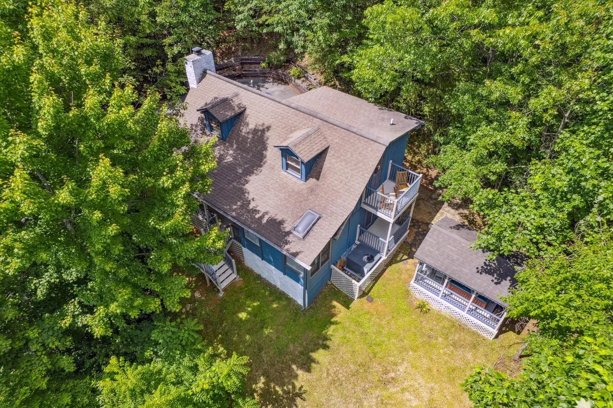 This exterior image features the main house with a balcony and a gazebo, surrounded by lush nature. The spaces invite outdoor relaxation, group gatherings, and family moments in a scenic environment.